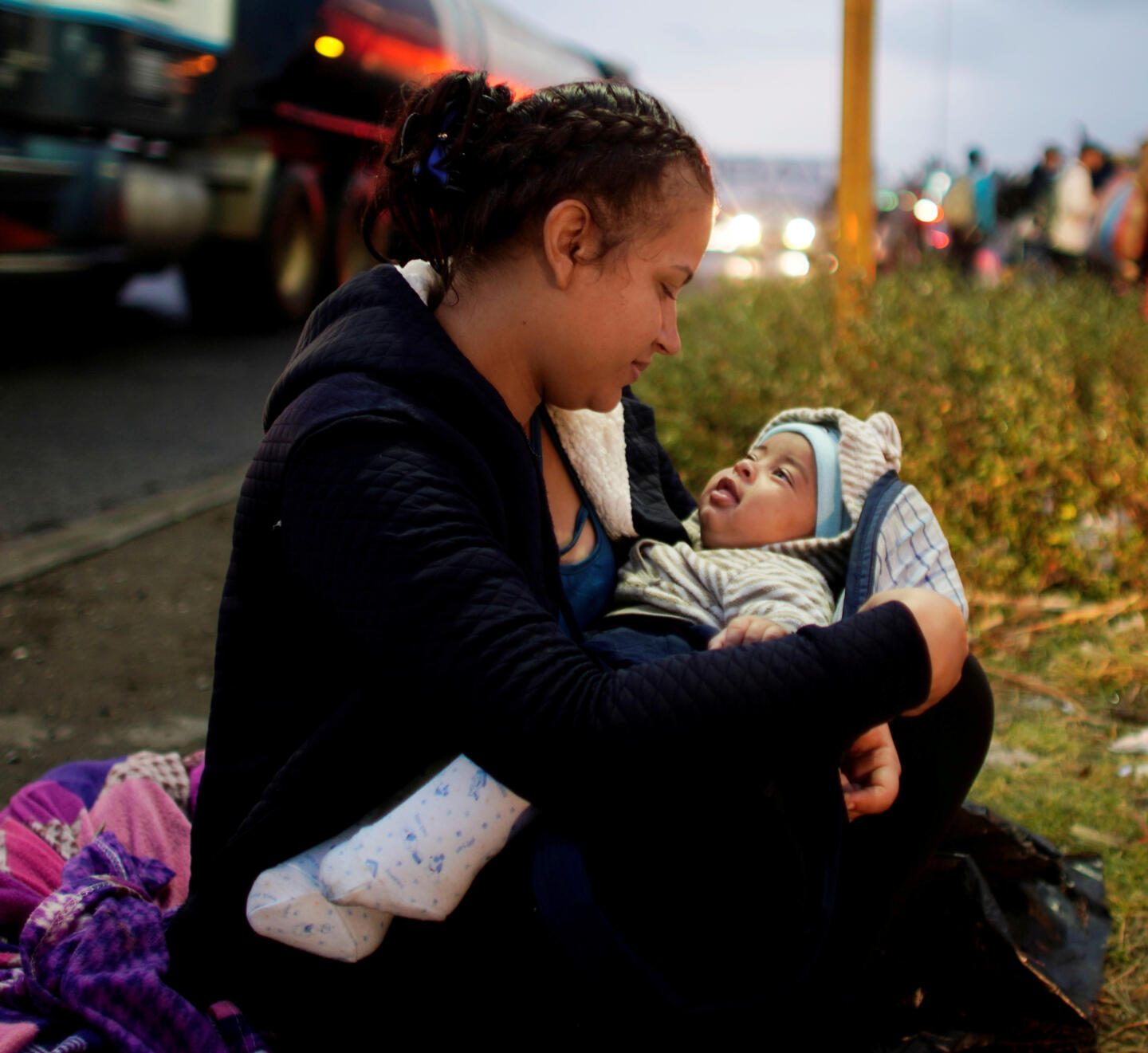 Migrant Marely Villatoro, 20, from Honduras, plays with her 4 months-old child as she waits for a lift during their journey towards the United States, in Tierra Blanca, Mexico