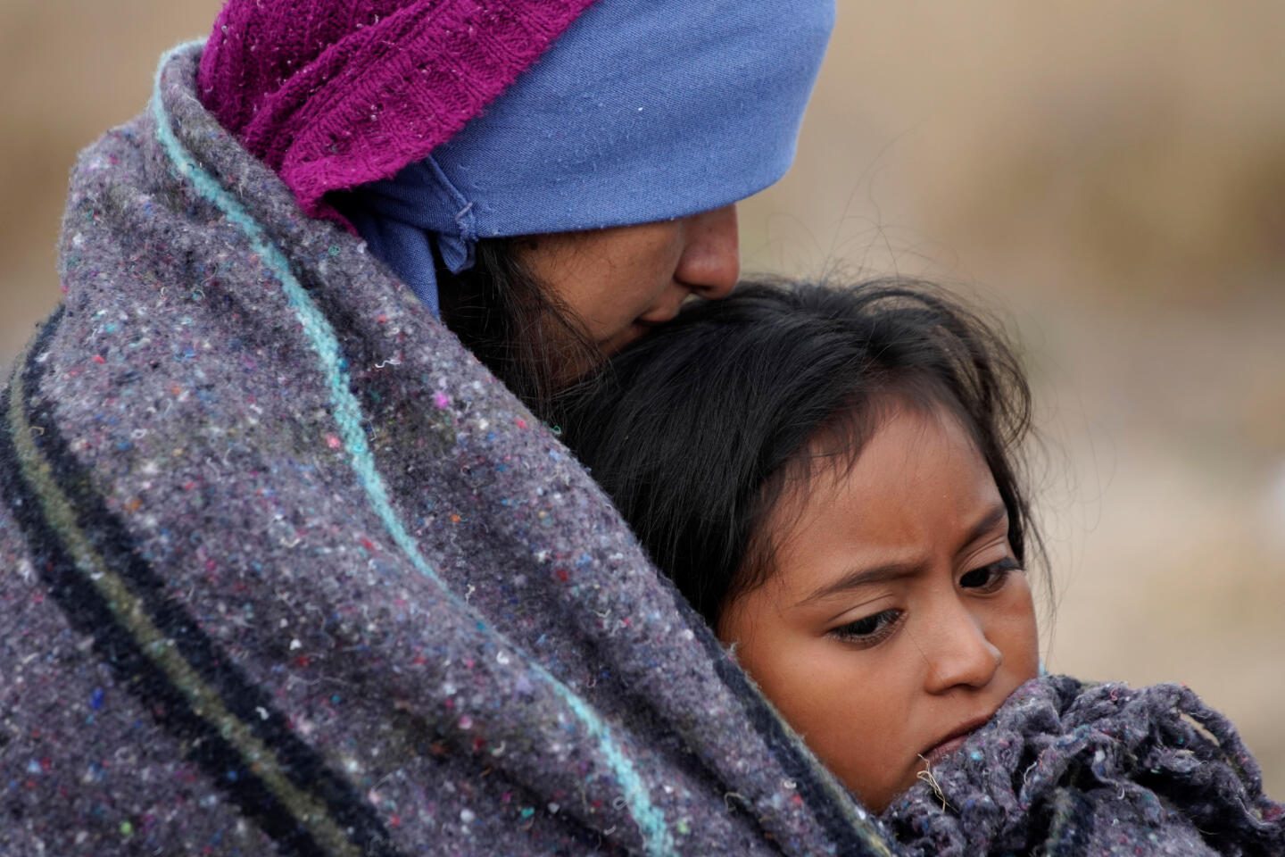 Migrant Yoselin Dias, 9, from Honduras, is held by her mother as they wait for transportation during their journey towards the United States, in Matehuala, Mexico